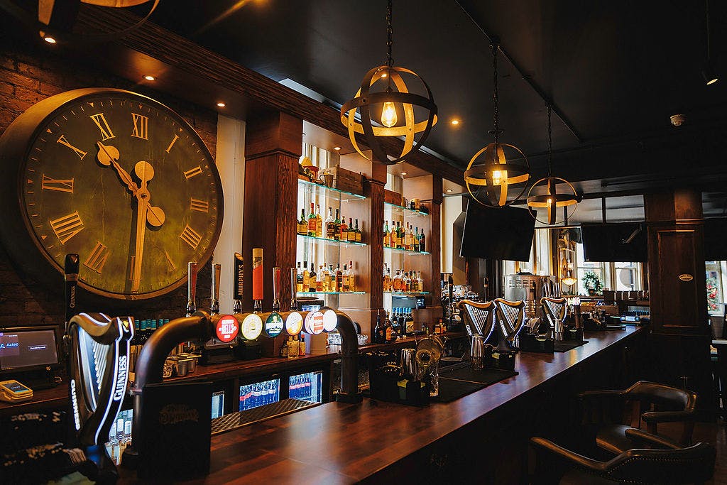 Interior bar at Dirty O’Sullivans Irish pub in Manchester city centre with Guinness taps and whiskey display