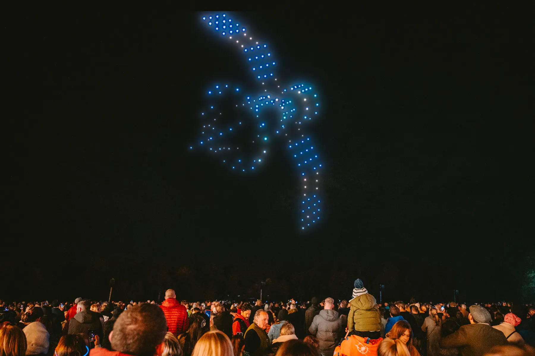 Night sky aerial display with illuminated drone patterns